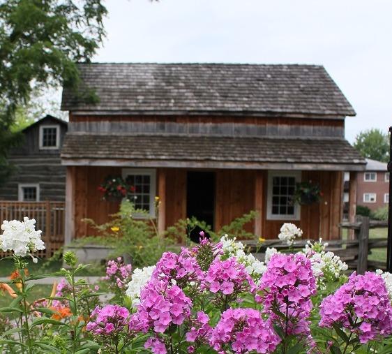 Rustic wooden house with colorful flowers in the foreground.